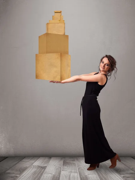 Jovem segurando um conjunto de caixas de papelão marrom — Fotografia de Stock