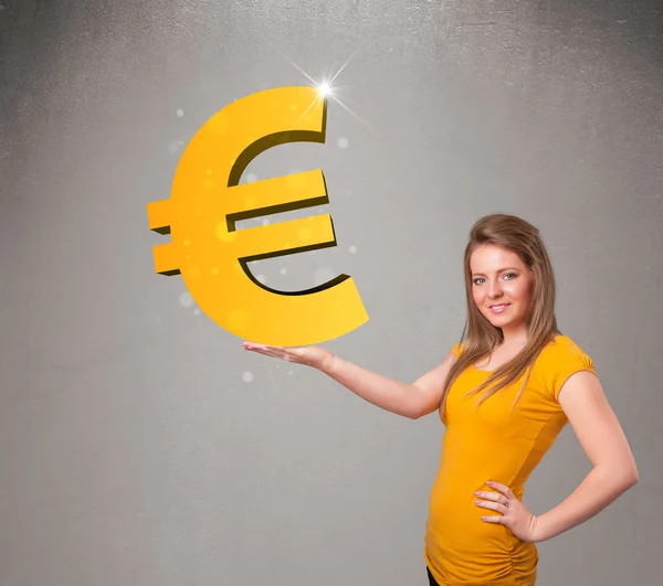 Beautiful girl holding a big 3d gold euro sign — Stock Photo, Image