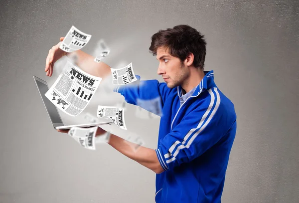 Jongeman met een laptop en het lezen van het explosieve nieuws — Stockfoto