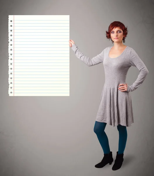 Jeune femme tenant un espace de copie en papier blanc avec des lignes diagonales — Photo