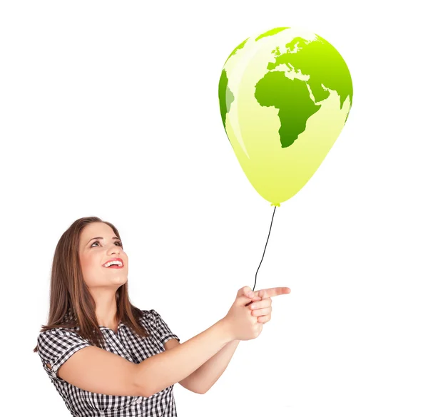 Senhora feliz segurando um balão globo verde — Fotografia de Stock