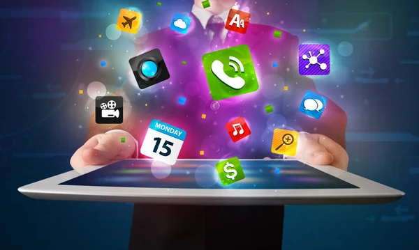 Zakenman die een tablet vasthoudt met moderne kleurrijke apps en pictogrammen — Stockfoto