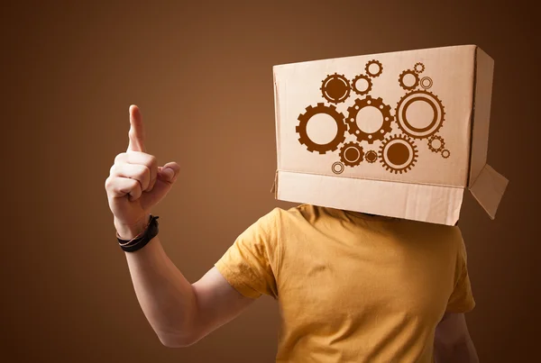 Young man gesturing with a cardboard box on his head with spur w — Stock Photo, Image