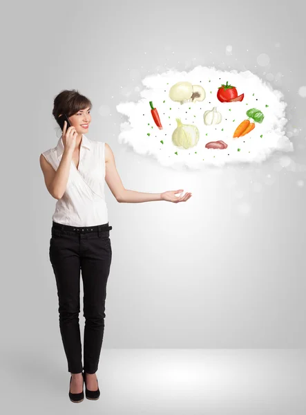 Mujer bonita presentando una nube de vegetales nutritivos saludables — Foto de Stock