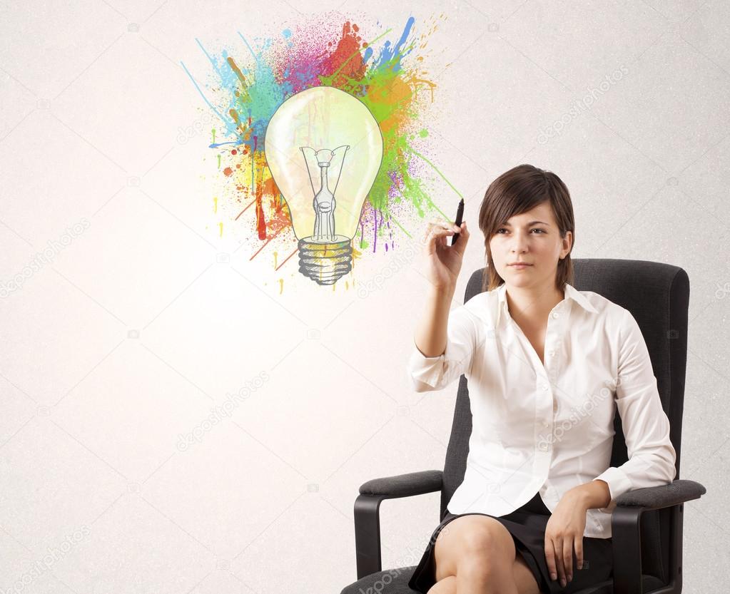 Young lady drawing a colorful light bulb with colorful splashes