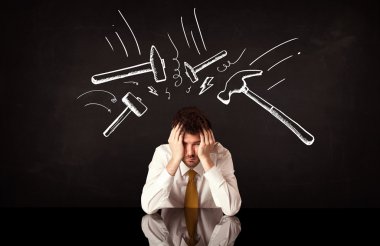 Depresyondaki işadamı çekiç izlerinin altında oturuyor