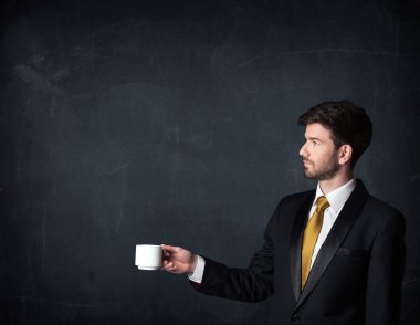 Beyaz bir bardak tutan işadamı