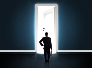 Büyük parlak kapıyı açan bir iş adamı.