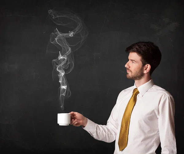 Businessman holding a white steamy cup — Stock Photo, Image