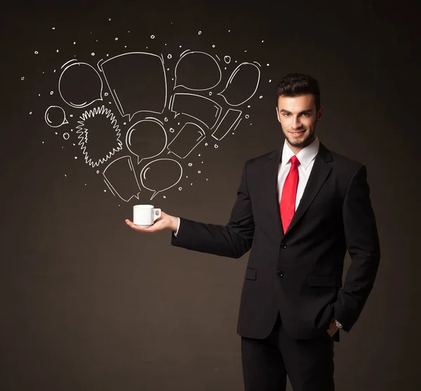 Businessman holding a white cup with speech bubbles — Stock Photo, Image