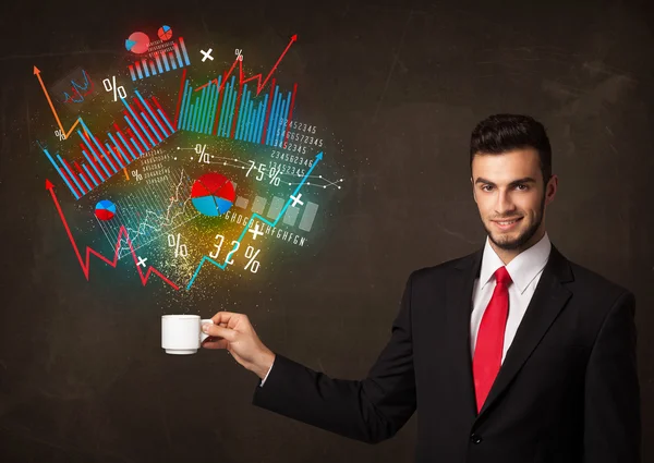 Empresario sosteniendo una taza blanca con diagramas y gráficos — Foto de Stock