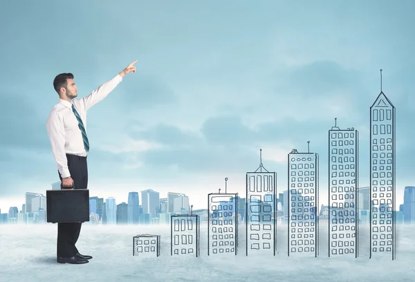 Business man climbing up on hand drawn buildings in city — Stock Photo, Image