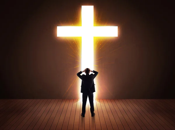 Man looking at bright cross sign — Stock Photo, Image