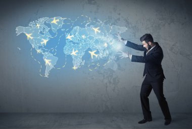 Dünyanın dört bir yanındaki uçaklarla dijital harita gösteren bir iş adamı