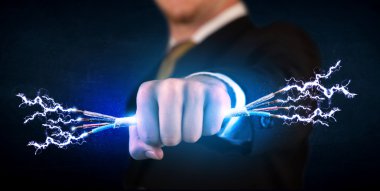 Elektrik kablolarını tutan iş adamı