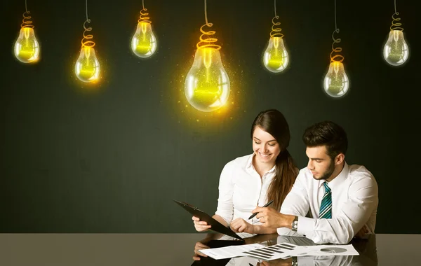 Casal de negócios com lâmpadas ideia — Fotografia de Stock