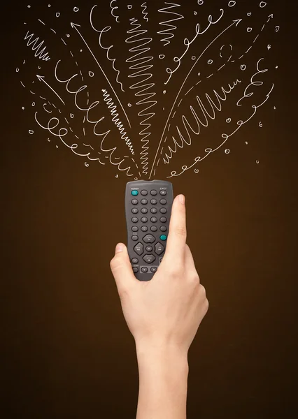 Hand with remote control and curly lines — Stock Photo, Image