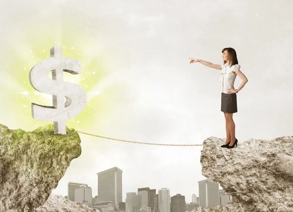 Businesswoman on rock mountain with a dollar mark — Stock Photo, Image