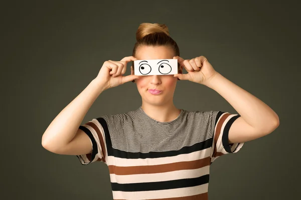 Mladá hloupá dívka dívá s ručně kreslené oční koule na papíře — Stock fotografie