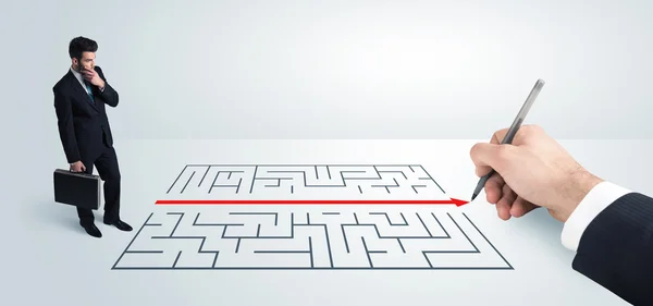 Affärsman tittar på handritning lösning för labyrint — Stockfoto