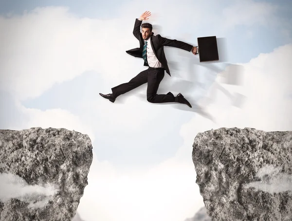 Funny business man jumping over rocks with gap — Stock Photo, Image