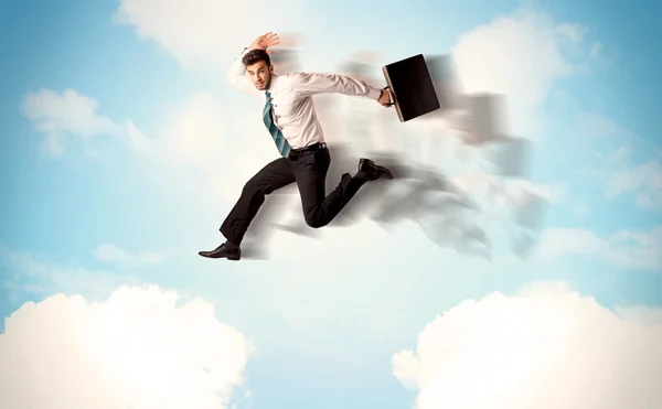 Business person jumping over clouds in the sky — Stock Photo, Image