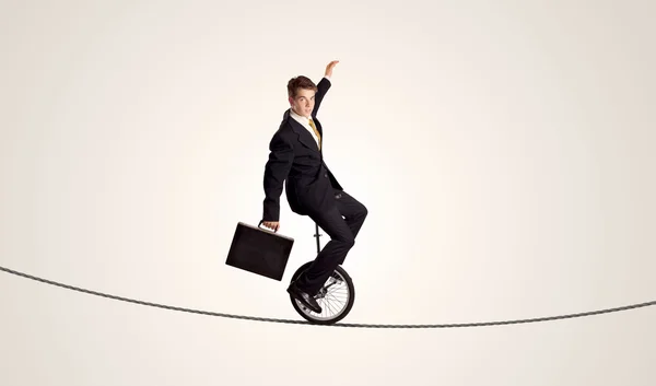 Hombre de negocios extremo montando monociclo en una cuerda — Foto de Stock