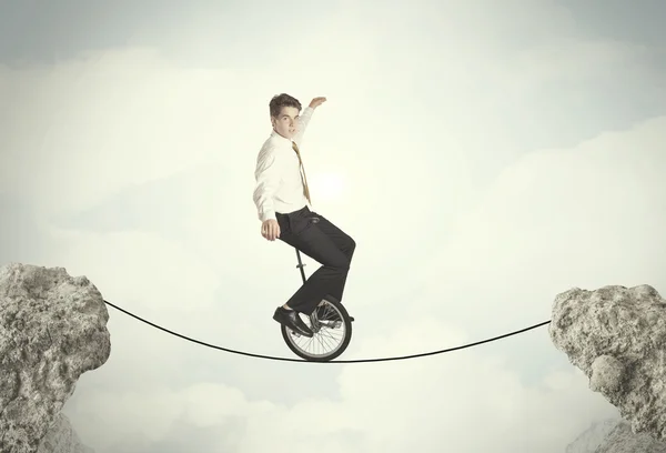 Brave business man riding an mono cycle between cliffs — Stock Photo, Image