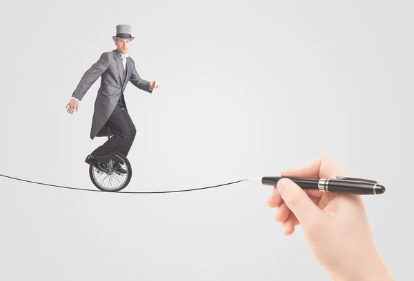 Businessman riding monocycle on a rope drawn by hand — Stock Photo, Image