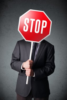 İşadamı elinde dur levhası tutuyor.