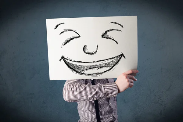 Empresário segurando um papel com rosto sorridente na frente de sua hea — Fotografia de Stock