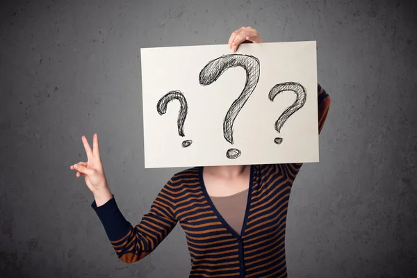 Woman holding paper with drawed question marks in front of her h — Stock Photo, Image