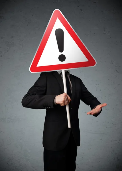 Businessman holding an exclamation road sign — Stock Photo, Image