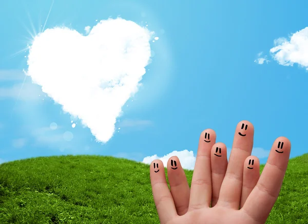 Happy smiley fingers looking at heart shaped cloud — Stock Photo, Image