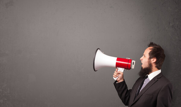 Guy shouting into megaphone on copy space background