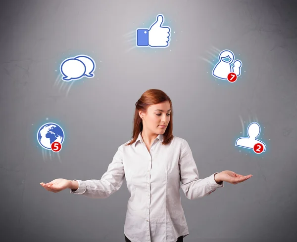 Attractive young woman juggling with social network icons — Stock Photo, Image