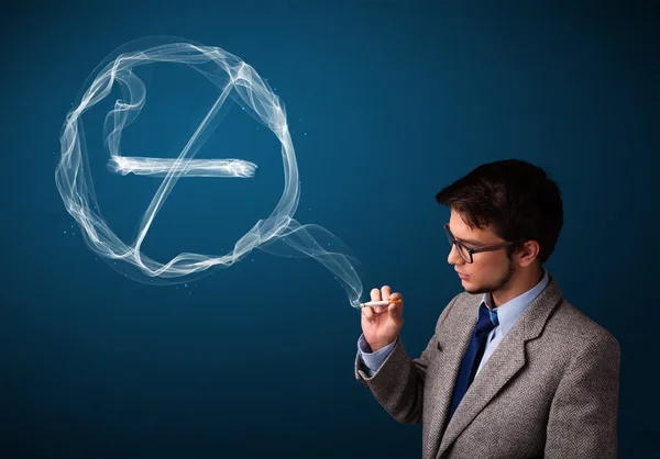 Young man smoking unhealthy cigarette with no smoking sign — Stock Photo, Image