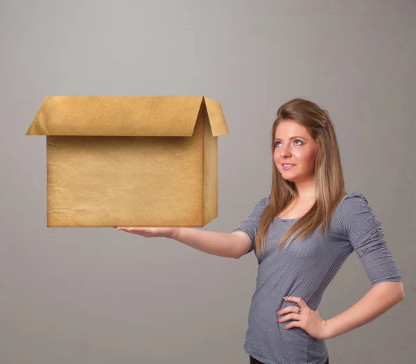 Jeune femme tenant une boîte en carton vide — Photo