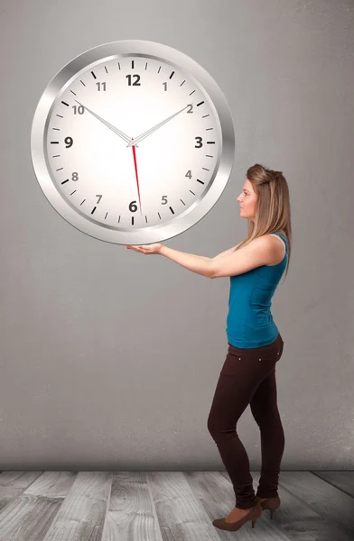 Attractive lady holding a huge clock — Stock Photo, Image