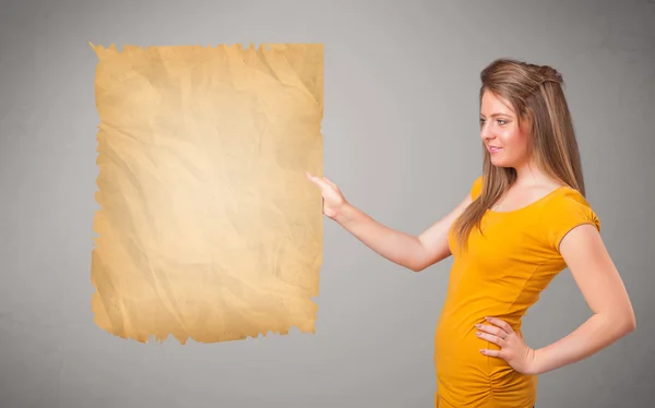 Young girl presenting old paper copy space — Stock Photo, Image