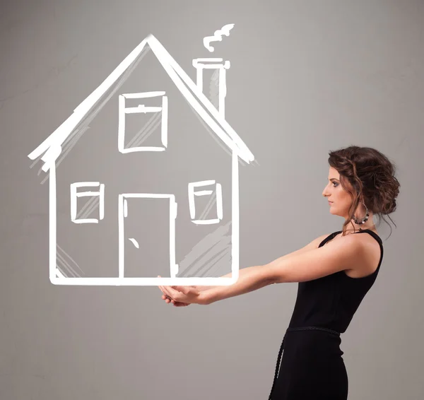 Young lady holding a huge drawn house — Stock Photo, Image