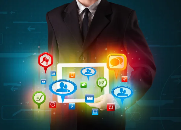 Бизнесмен представляет современный планшет с красочными социальными знаками — стоковое фото