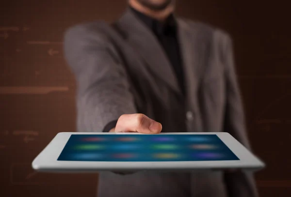 Uomo d'affari in possesso di un tablet bianco moderno con applicazioni sfocate — Foto Stock