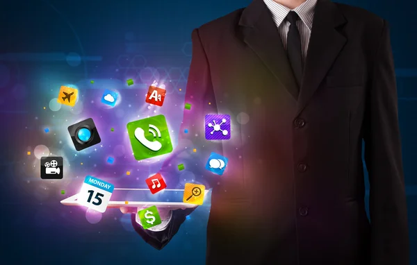 Businessman holding a tablet with modern colorful apps and icons — Stock Photo, Image