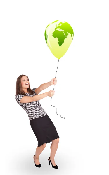 Happy lady holding a green globe balloon — Stock Photo, Image