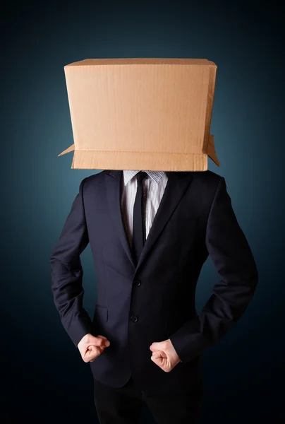 Businessman gesturing with a cardboard box on his head — Stock Photo, Image