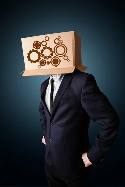 Empresário gesticulando com uma caixa de papelão na cabeça com esporão — Fotografia de Stock