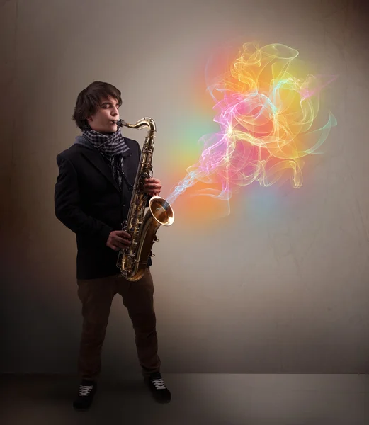 Attraente musicista che suona su sassofono con astratto colorato — Foto Stock