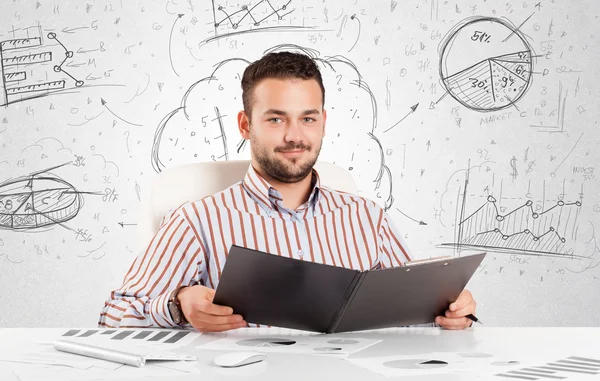 Geschäftsmann sitzt mit handgezeichneten Diagrammen am Tisch — Stockfoto