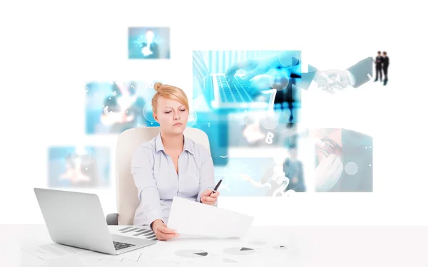 Business person at desk with modern tech images at background Stock Photo